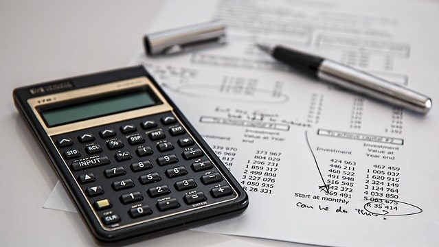 A calculator, a sheet of numbers and a pen