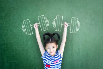 Empowering woman and girl gender rights concept for international day of girl child, and sports for development and peace with healthy strong kid with dumbbell exercise doodle on school chalkboard