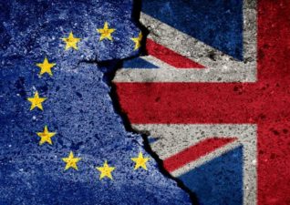 EU and UK flag on broken wall