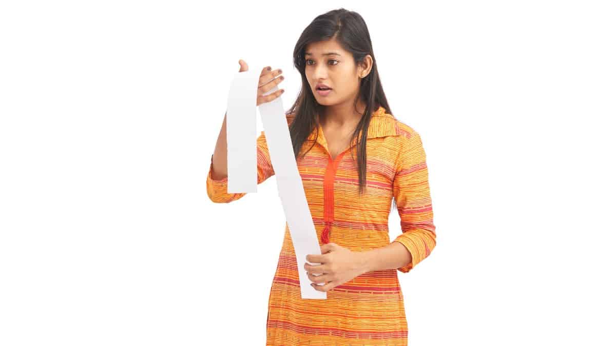 Shocked young woman looking at a store receipt