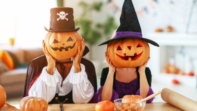 Halloween concept. a couple of people dressed as witches and vampires with pumpkins for heads