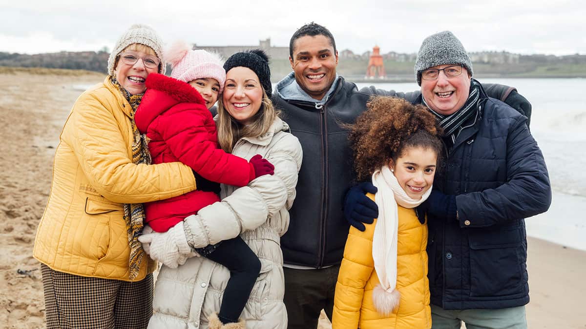 A multi-generational family at the beach on a winter's day
