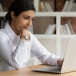 Smart young brown businesswoman working from home on a laptop