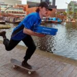 Dominos delivery man on skateboard holding pizza boxes