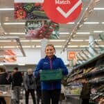 Female Tesco employee holding produce crate