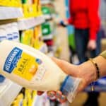 Lady taking a bottle of Hellmann's Real Mayonnaise from a supermarket shelf