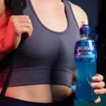 Young woman carrying bottle of Energise Sport to the gym