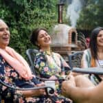 Pakistani multi generation family sitting around a table in a garden in Middlesbourgh, North East of England.