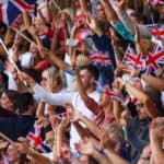 UK coloured flags waving above large crowd on a stadium sport match.