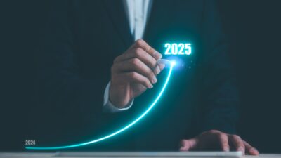 Businessman using pen drawing line for increasing arrow from 2024 to 2025