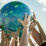 Close-up of children holding a planet at the beach
