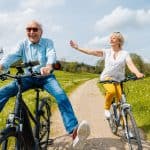 Seniors having fun on bicycles in spring landscape